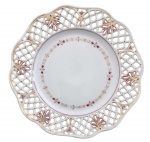 Prato decorativo em porcelana alemã, modelo rendado com borda vazada, delicada decoração floral em púrpura e dourado e filetes em ouro. Peça de elegante acabamento, com numeração manuscrita ao verso. Meados século XIX. Medida: 23 cm de diâmetro.