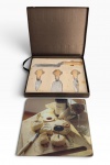 CONJUNTO de facas PARA QUEIJOS, composto por tábua de pasta de vidro e utensílios em estojo original.Sem uso. Medida da caixa: 27 x 22 cm