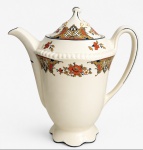 WOODS IVORY WARE  ENGLAND  Bule de porcelana inglesa, em tonalidade marfim, com rica decoração floral e ornamental em tons de laranja, dourado, azul e preto, tampa com pináculo e elegante pé recortado. Marca na base. Medidas: 20 cm de altura.