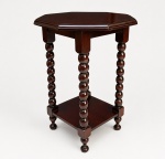 MESA DE APOIO EM ESTILO clássico português, em madeira escura, com tampo octogonal, colunas torneadas e prateleira inferior, destacando-se pelo trabalho ornamental e elegância do conjunto. Inicio séc. XX. Medidas: Altura 55 x 40 cm.