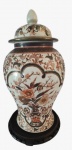 Elegante Potiche em porcelana oriental estilo Imari, caracterizado pela rica pintura floral e detalhes em tom de ferrugem. Acompanha base em madeira. Medida: Altura 48 cm e Diâmetro 25 cm. 