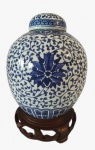 Potiche em porcelana com pintura na tonalidade azul em tema floral , acompanha base em madeira. Obs: Tampa quebrada e colada. Medidas: Altura 23 cm e Diâmetro 18 cm.