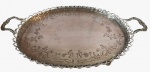 Bandeja em metal espessurado a prata com bordas vazadas em tema floral com quatro pés de sustentação. Obs: necessita de solda em dois pés. Medidas: Altura 5 cm, Largura 34 cm e Comprimento 55 cm. 