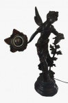 Luminária de mesa eum pettit bronze representando uma figura feminina para uma lâmpada com cúpula em formato de flor na tonalidade âmbar. Medida: Altura 60 cm.