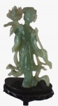 Escultura em Jade esculpida artesanalmente com base em madeira representando figura feminina. Medidas: Altura 20 cm, Largura 6 cm e Comprimento 12 cm.