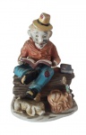 Escultura em porcelana pintado artesanalmente representando um senhor. Medidas: Altura 15 cm, Largura 10 cm e Comprimento 12 cm.