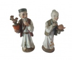 Par de antigas esculturas em porcelana japonesa pintado artesanalmente representando um casal de senhores. Obs: uma escultura com a cabeça e a mão quebrada e colada. Medida: Altura 15 cm e Diâmetro 5 cm. 