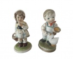 Lote com duas esculturas em porcelana pintado artesanalmente representando duas crianças. Medidas: Altura 14 cm e Diâmetro 6 cm.