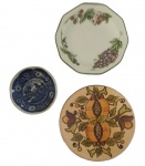Lote com três pratos decorativos em  porcelana diversos. Medida maior: Diâmetro 20 cm.