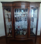 Cristaleira em madeira maciça com uma porta em vidro ovalado e bisotado. RETIRADA PELO COMPRADOR. Medida: altura 1,35 cm largura 42 cm comprimento 1,12.