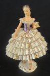 Escultura em porcelana pintado artesanalmente em tema de bailarina. Obs: dois mínimos pedaços quebrados na saia. Medida: altura 15 cm largura 8 cm comprimento 12 cm.