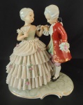 PORCELANA REBIS- Escultura em porcelana pintada artesanalmente representando um homem e uma mulher. Obs: três quebrados na saia. Medida: altura 18 cm largura 10 cm comprimento 15 cm.