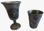 Lote com duas peças em ferro prateado sendo um cálice e um copinho. Medida maior: altura 8 cm diâmetro 5 cm.
