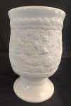 Floreira em porcelana com desenhos em tema floral em alto relevo. Medida: altura 12 cm diâmetro 8 cm. 