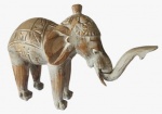 Escultura  indiana em madeira esculpida e pintada artesanalmente representando um elefante com a tromba articulada. Medida: altura 30 cm largura 16 cm comprimento 40 cm.