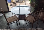Mesa em vime para quatro lugares com estrutura em ferro e tampo de vidro. RETIRADA PELO COMPRADOR.*Medida mesa*: altura: 75 cm diâmetro 1 mt /  *medida  cadeira*: altura 90 cm largura 43 cm comprimento 40 cm. 
