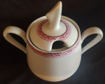 PORCELANA ESTEATITA - Açucareiro em porcelana com borda trabalhada na tonalidade rosa e dourada. Medida: altura 8 cm diâmetro 10 cm. 