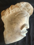 Escultura em mármore apresentando uma face humana esculpida artesanalmente. Peça proveniente da Grécia. Medida: altura 8 cm largura 21 cm comprimento 20 cm.