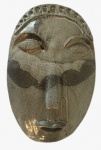 Escultura de parede em cerâmica representando uma máscara indígena. Peça assinada. Medida: 35x23. 