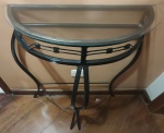 Mesa aparador meia lua em ferro fundido na tonalidade preto e dourado  com tampo de vidro. RETIRADA PELO COMPRADOR Medida: altura 85 cm largura 27 cm comprimento 65 cm. 