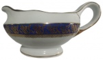 REAL - Molheira em porcelana branca pintado artesanalmente com guirlandas na tonalidade dourado e fundo azul. Medidas: 10 cm de altura, 13 cm de largura e comprimento 20 cm.