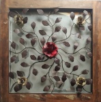 Quadro com moldura em madeira e espelho de fundo, com apliques em ferro representando flores. Observação: Retirada pelo comprador. Medidas: 85 x 85 cm.