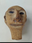 Ex voto sendo uma   cabeça de cego em barro  origem Pernambuco ex-voto (também conhecido popularmente como "milagre" ou peça de "promessa"). Trata-se de uma escultura votiva tradicionalmente oferecida em santuários como forma de agradecimento por uma graça alcançada  neste caso específico, provavelmente uma cura ou proteção relacionada à cabeça. medidas  16 x 10 cm