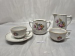 Jogo de leiteira, açucareiro (sem tampa), 2 xícaras (1 pires) em porcelana, canelado, floral. Medindo a xicara 6,5cm x 4cm de altura. Contém bicados.