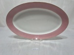 Travessa oval rasa em porcelana, friso ouro, barra rosa. Medindo 36,5cm x 24cm. Contém desgastes.