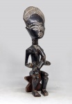 Gana, Africa? MATERNIDADE. Escultura em madeira oriunda possivelmente da tradição escultórica da etnia Ashanti, de Gana. Altura = 37 cm. Na cena, veem-se a mãe, sentada, a amamentar o filho, no colo. Perna colada. Obs.: Parece faltar parte da peça - uma mamadeira?