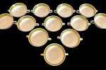 BRENNAND. Doze xícaras para consummé em porcelana nacional esmaltada na cor branca, decorada com faixa verde e rica ornamentação em ouro, composta por frisos e motivos fitomorfos. Manufatura marcada no verso, medidas: 5 x 15 x 11,5 cm. Sem pires/Ausência dos respectivos pires