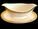 BRENNAND. Molheira em porcelana nacional esmaltada na cor branca, decorada com faixa verde e rica ornamentação em ouro, composta por frisos e motivos fitomorfos. Manufatura marcada no verso. Medidas: 8 x 23 x 15 cm