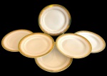 BRENNAND. Seis pratos rasos em porcelana nacional esmaltada na cor branca, decorada com faixa verde e rica ornamentação em ouro, composta por frisos e motivos fitomorfos. Manufatura marcada no verso. Medidas: 24,5 cm. Um com discretíssimo bicado e outro apresenta um fio de cabelo e restauração.