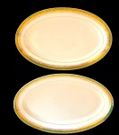 BRENNAND. Duas travessas em porcelana nacional esmaltada na cor branca, decorada com faixa verde e rica ornamentação em ouro, composta por frisos e motivos fitomorfos. Manufatura marcada no verso. Medidas: 36,5 x 23,5 cm. / 32 x 20,5cm. Travessa maior apresenta leves desgastes.
