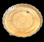 Antiga bandeja circular em metal espessurado a prata, com centro gravado com guirlanda de motivos florais e fitomorfos, reserva central e delicados frisos. Aba recortada, ricamente trabalhada em relevo e vazados, com ornamentação floral. Apresenta sinais do tempo e de uso, com pontos de desgaste e oxidação do prateado. Medidas: 4,5 x 35 cm de diâmetro.