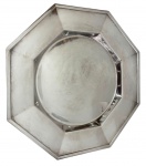 ST. JAMES. Antiga travessa em metal espessurado a prata, de formato octogonal, com aba larga facetada, centro circular rebaixado. Apresenta discretas marcas do tempo. Medidas: 39 cm de diâmetro x 2,5 cm de altura.
