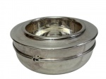 Antiga manteigueira térmica em metal espessurado a prata, de formato circular, composta por recipiente externo e cuba interna removível. Medidas: 9,5 x 20,5 cm.