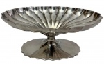 Sheffield. Antiga fruteira em metal espessurado a prata, de formato oval, com corpo canelado e gomado em relevo, bordas recortadas e elevada sobre pé central com base oval igualmente gomada. Medidas: 20,5 x 13,5 x 8,5 cm.