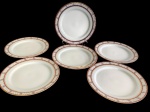 SCHMIDT. Conjunto de 6 pratos rasos em porcelana nacional, com elegante decoração, composta por frisos geométricos e pequenos motivos florais policromados, realçados por filetes dourados. Medidas: 26 cm de diâmetro.