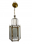 Antigo lustre tipo lanterna em metal, de estrutura sextavada, com armação vazada, pináculos decorativos e painéis em vidro bisotado. Suspenso por corrente e canopla em metal. Observação: um dos vidros apresenta quebra em um dos cantos. Medidas: 51 x 22,5 cm. Altura total com a corrente: 83 cm.