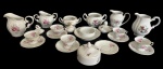 Conjunto de peças variadas em porcelana, com delicadas decorações florais policromadas e detalhes dourados, composto por leiteiras, açucareiros, manteigueira e seis xícaras com respectivos pires, em diferentes padrões florais. Medidas: leiteiras: 13,5 x 13 x 9,5 cm; 12,5 x 8,5 x 11 cm; 13,5 x 7,5 x 12 cm. Açucareiros: 11 x 15,5 x 12,5 cm; 10 x 14,5 x 8 cm; 13,5 x 7 x 12 cm. Manteigueira: 14,5 x 8 cm. Observação: um dos açucareiros apresenta leve bicado na borda interna e um dos seis pires apresenta leve bicado.