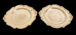 EBERLE - Par de pequenas bandejas em metal espessurado a prata, de formato circular com contorno recortado e moldurado, abas largas com discretos ornamentos em relevo nas laterais. Medidas: 21 x 18,7 cm.