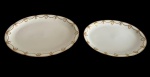 E. BOURGEOIS, France. Par de antigas travessas ovais em porcelana francesa, com decoração em delicados festões e motivos florais estilizados em dourado, distribuídos ao longo das bordas. Marcadas na base E. Bourgeois, Paris, tradicional casa francesa de porcelanas e cristais. Uma das travessas apresenta discreto bicado na borda. Medidas: 41 x 29 x 3 cm e 35 x 24,5 x 3,5 cm.