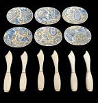 Conjunto de 12 peças em porcelana, composto por 6 espátulas para patê ou manteiga em porcelana branca, com delicado filete dourado, acompanhadas de 6 pequenos pratos ovais de apoio, decorados com exuberantes motivos florais e arabescos em tons de azul e dourado. Medidas dos pratos: 7 x 8,7 cm. Comprimento das espátulas: 12 cm.