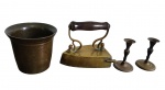 Conjunto de quatro peças antigas em metal, composto por pilão em bronze, par de castiçais e antigo ferro de passar em latão, este com alça em madeira torneada, apresentando marcas do tempo e de uso. Medidas: pilão 12,3 x 10,8 cm; castiçais 9 x 6 cm; ferro 14 x 13 x 8,5 cm.