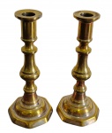 Par de antigos castiçais em metal dourado, de fuste torneado e escalonado, sobre bases octogonais molduradas. Apresentam desgastes no acabamento dourado e marcas do tempo. Medidas: 19 x 8 cm.