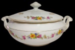 REAL, Brasil. Antiga sopeira em porcelana, de corpo bojudo, com alças laterais recortadas e tampa com puxador. Decoração floral policromada em delicadas guirlandas e ramagens, realçada por filetes dourados. Medidas: 27 x 23 x 16 cm.