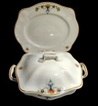 São Caetano, Brasil. Antiga sopeira em porcelana, acompanhada de travessa de formato quadrangular com cantos arredondados e alças laterais. Decorada com motivos florais policromados e elementos ornamentais, arrematados por filetes em tom ocre. Manufatura no verso. Apresenta marcas do tempo na parte interna. Medidas: sopeira 27,8 x 20 x 14 cm; travessa 30 x 25 x 2,5 cm.