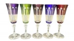 Conjunto de Cinco Taças em Cristal Europeu Lapidado "Cut to Clear" , exibindo na parte superior do cálice camada colorida externa em tonalidades de roxo, verde, ametista, azul-cobalto e rubi, lapidada em gomos canelados e gotas para revelar o cristal interno transparente, complementada por seção inferior com rica lapidação em bico de jaca, haste nodular lapidada e sólida base circular radiada com acabamento em estrela. Medidas: 20 cm de altura por 7 cm de diâmetro na boca.