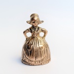 Sineta de mesa em bronze representando camponesa holandesa. Med 7 cm.